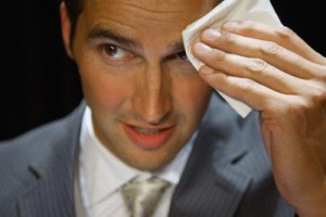 Businessman wiping forhead with handkerchief --- Image by © Beau Lark/Corbis